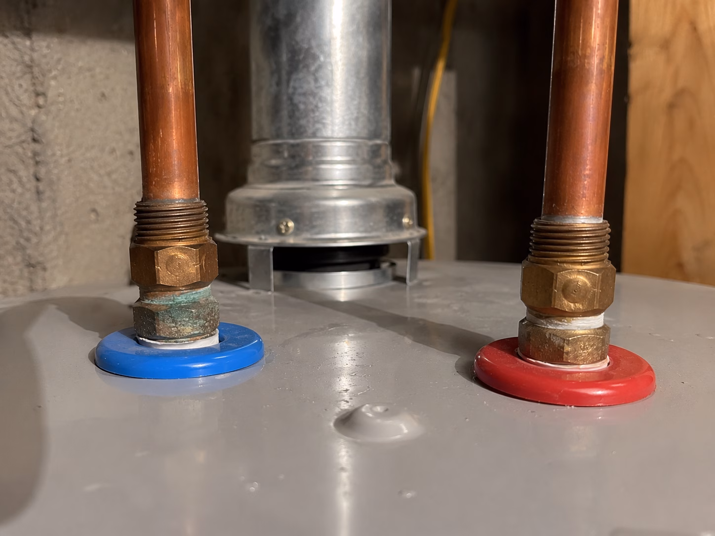 Top pipe connections of a water heater where leaks commonly start